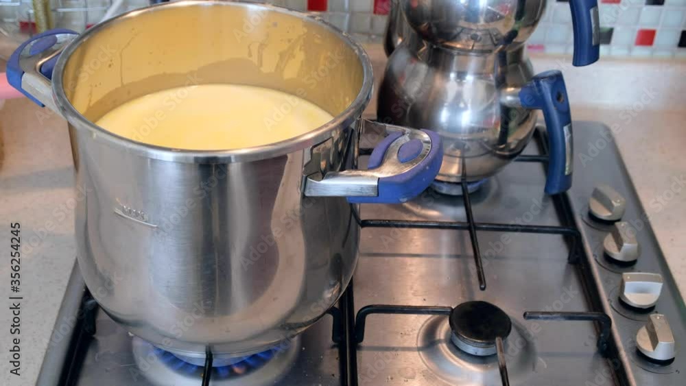 cooking raw cow's milk in the pot, cooking milk on the stove, cooking raw cow's milk in the pot, cooking milk on the stove,