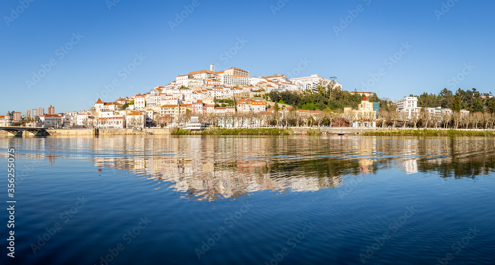 historic Coimbra cityscape with university at top of the hill in the evening, Portugal