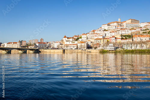 historic Coimbra cityscape with university at top of the hill in the evening, Portugal