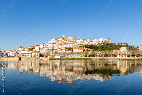 historic Coimbra cityscape with university at top of the hill in the evening, Portugal