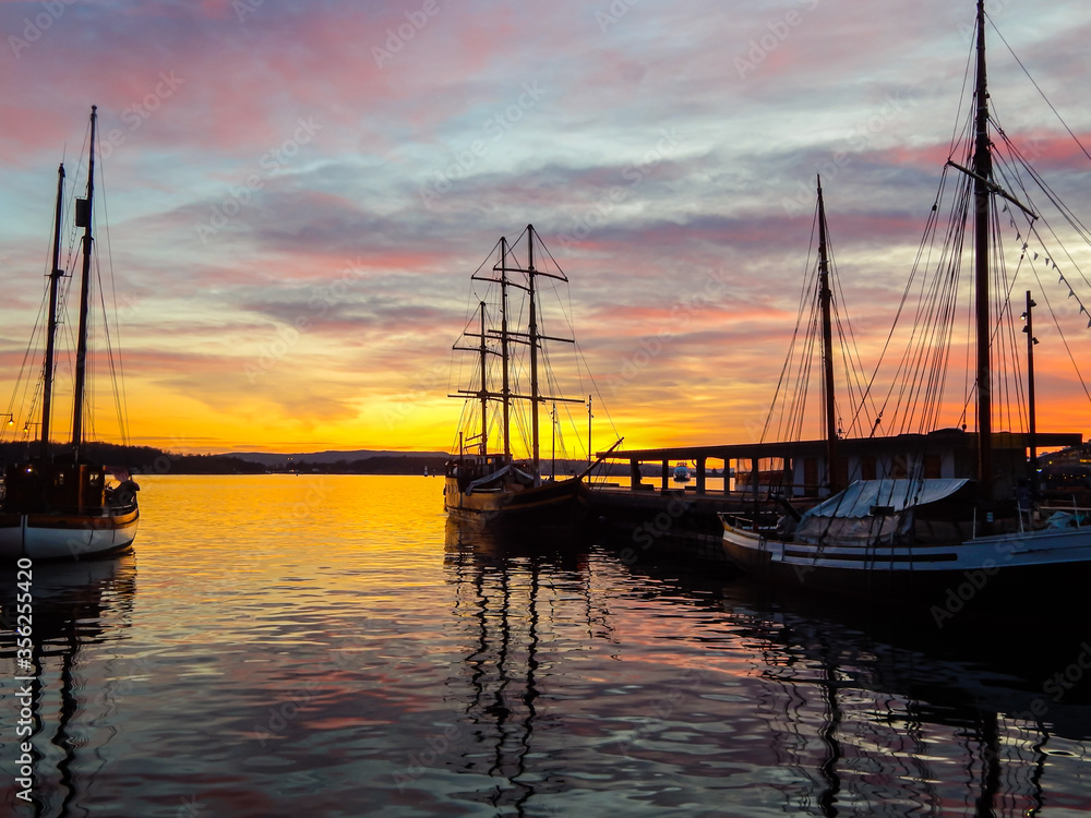 Scenic sunset over the harbour in Oslo, Norway. Gorgeous reflections in dark water.