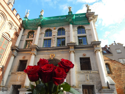 Red roses on the background of a beautiful vintage building. Gdansk, Poland.