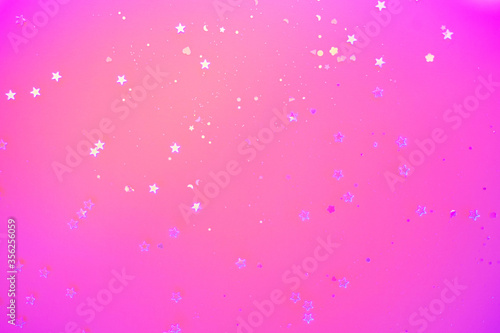 Holographic confetti with sparkles in trendy neon light. Festive concept.