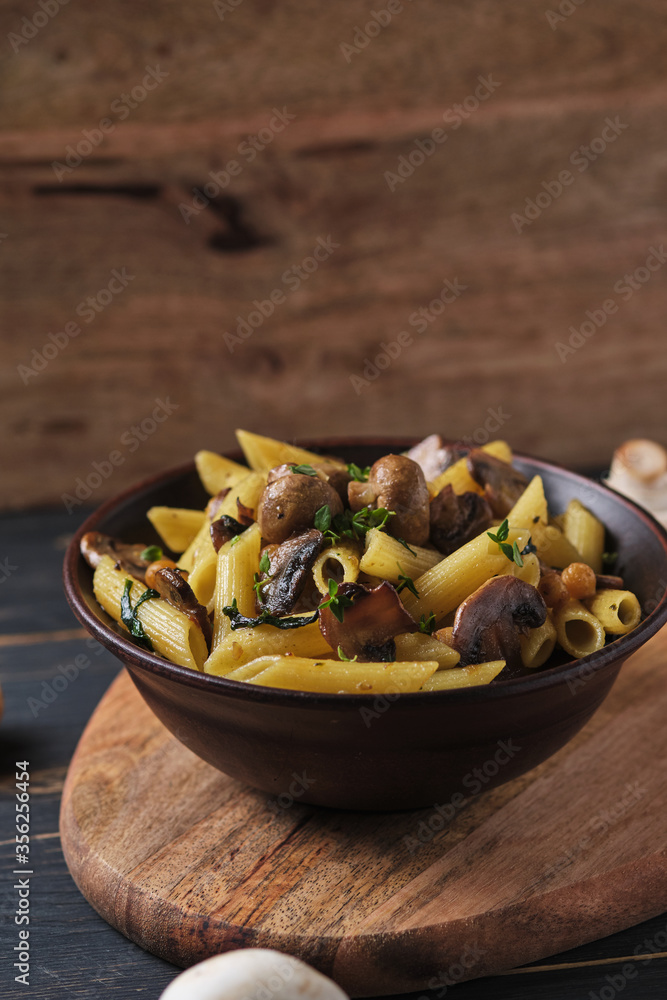 Vegetarian pasta with mushrooms, chickpeas, spinach, spices and herbs. Italian pasta in a bowl on an old wooden table. Vegetarian pasta with mushrooms, chickpeas, spinach, spices and herbs. Italian pasta in a bowl on an old wooden table.
