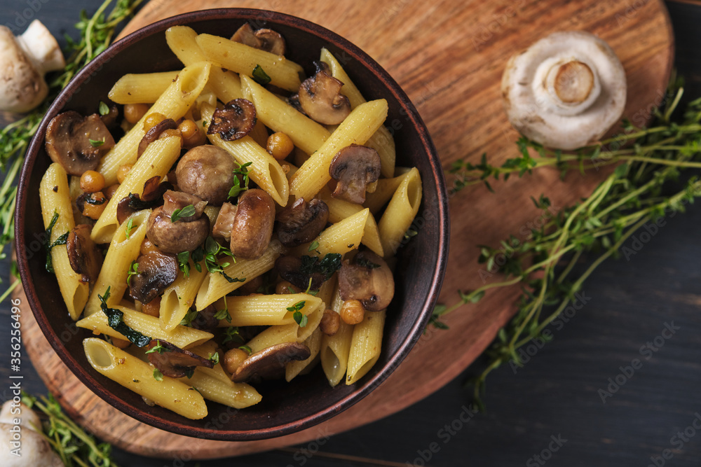 Vegetarian pasta with mushrooms, chickpeas, spinach, spices and herbs. Italian pasta in a bowl on an old wooden table. Top view. Vegetarian pasta with mushrooms, chickpeas, spinach, spices and herbs. Italian pasta in a bowl on an old wooden table. Top view.