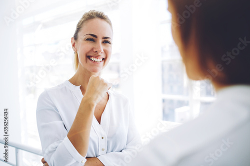 Two female employees having pleasant conversation after analyzing strategy on digital tablet