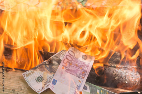 Euro and dollar bills are on fire. Burning a surplus of money. The concept of the collapse of the economy, devaluation. Crisis. Loss