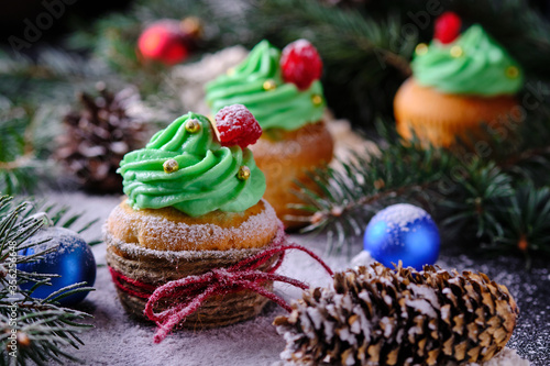 Christmas cupcakes in a festive and snowy forest. Dessert for New Year and Christmas celebration.