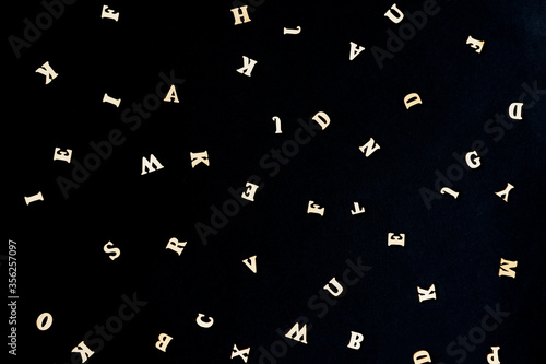 Light letters of the English alphabet on a black background. Education, school, study, reading concept