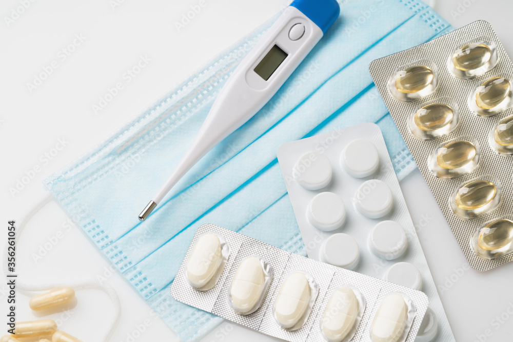 Medical digital thermometer and medical mask and pills. Medical concept Medical digital thermometer and medical mask and pills. Medical concept