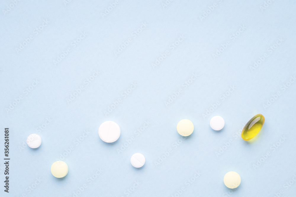 Pills on blue background. Copy space, top view Pills on blue background. Copy space, top view