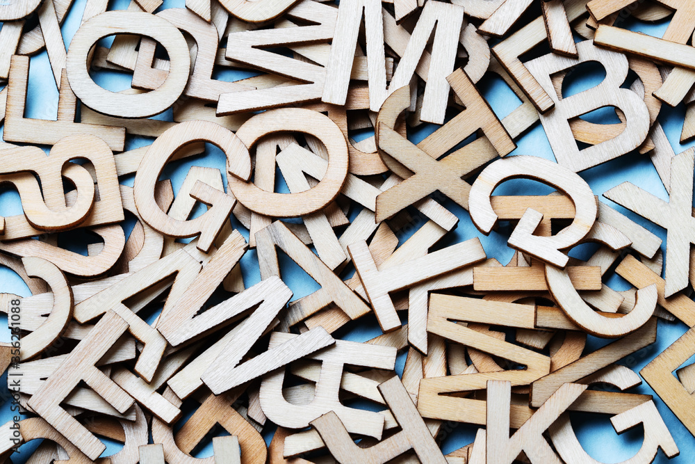 Mixed wooden letters close-up on a blue background Mixed wooden letters close-up on a blue background