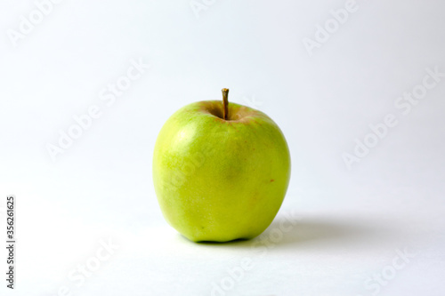 Big green apple close-up on a white background.