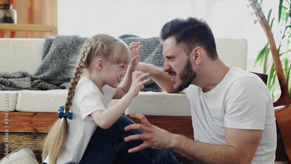 Fototapeta premium Father and daughter portrait. Loving and caring dad playing with his daughter at home.