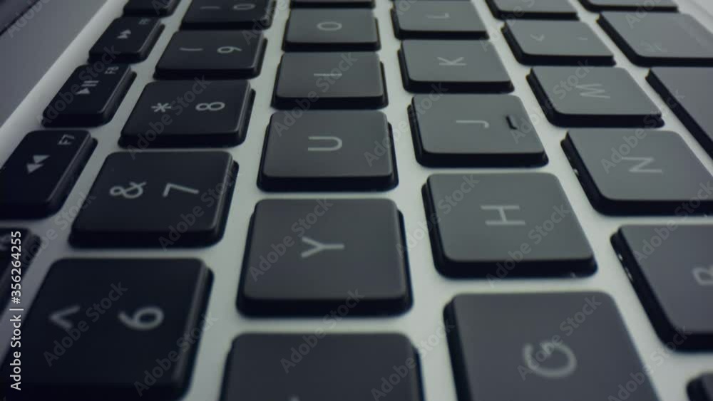 Keyboard on laptop computer. Dolly shot of grey laptop with black keys Keyboard on laptop computer. Dolly shot of grey laptop with black keys