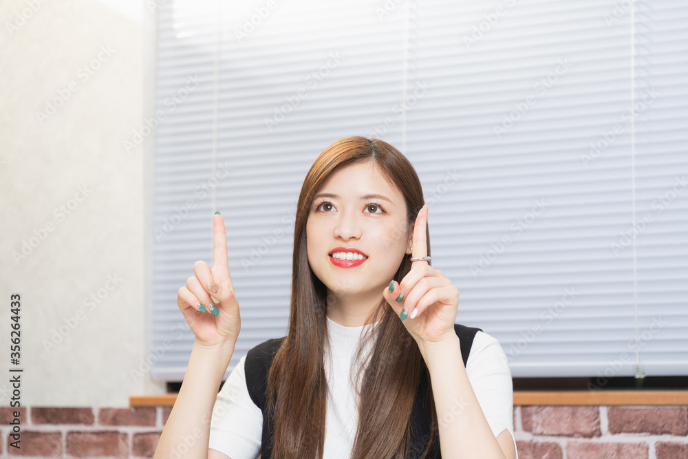 人差し指でポイントを指し示す女性 人差し指でポイントを指し示す女性