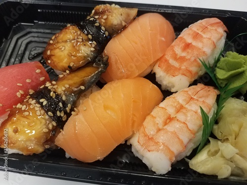 eel, salmon, shrimp, and tuna sushi in a black plastic container