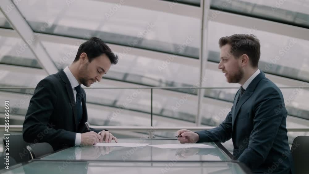 Happy businessman signing a contract Happy businessman signing a contract