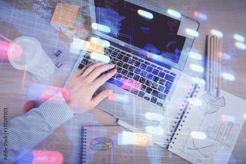 Multi exposure of man's hands typing over computer keyboard and data theme hologram drawing. Top view. Technology concept.