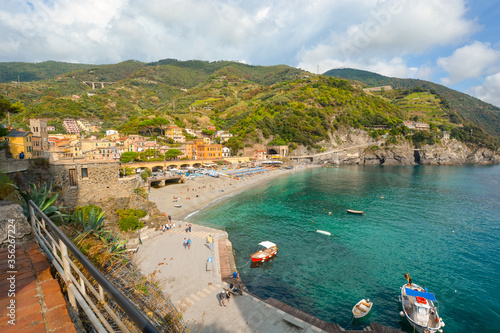 Fototapeta Naklejka Na Ścianę i Meble -  The sandy beach Spiaggia di Fegina at the old side of the Cinque Terre Italy resort village of Monterosso al Mare with tourists and boats in the sea
