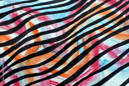 Striped fabric texture. Black waves on a multicolored background. Orange, pink, and blue spots and black lines.
