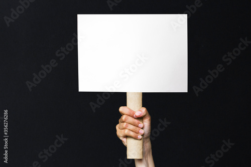 activist with an empty poster. protest banner on black background