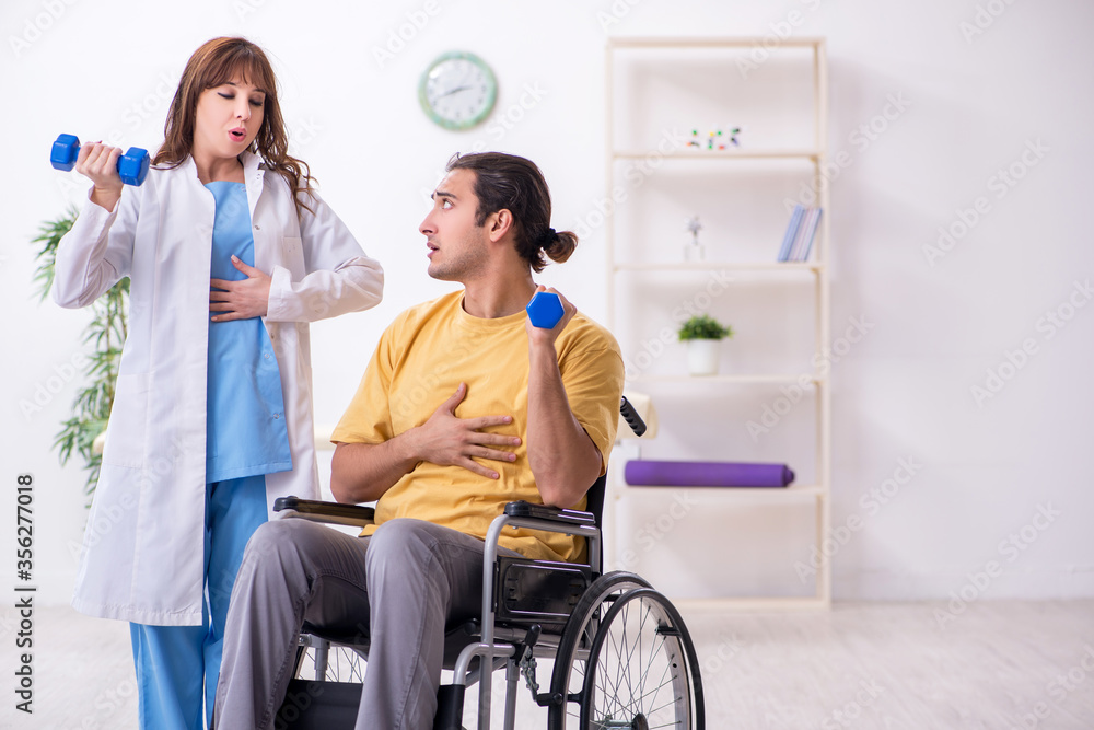 Young male patient in wheel-chair doing physical exercises Young male patient in wheel-chair doing physical exercises