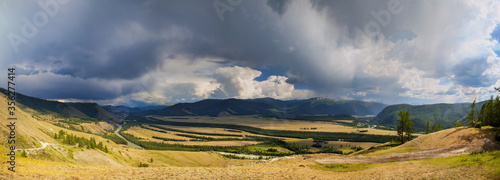 Above the mountain valley  the river flows among the mountains  Altai. Stormy sky  panoramic view.