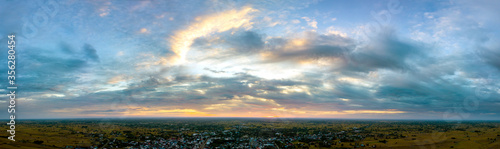 Panorama Top view Aerial photo from flying drone over village in Thailand.Top view beautiful Sunset.Sunrise with cloud over rice field.