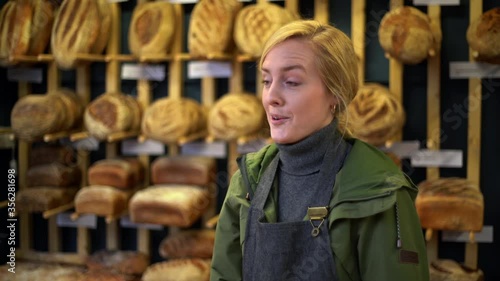 Blond woman working at bakery on Norwich market, England. photo