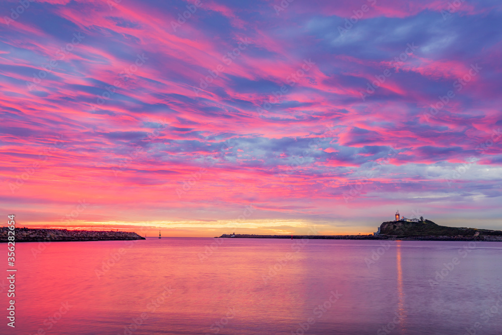 Colourful,winter's sunrise over Newcastle Harbour. Nobbys Lighthouse in distance.Hunter region of  N.S.W. Australia. 