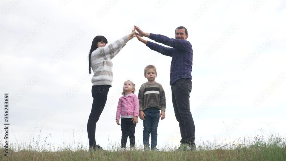 happy family. teamwork adult parents and small children shows a house and comfort symbol. happy family mom dad and kids children portray a house roof hold their lifestyle hands over their heads