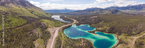 Drone aerial view of the amazing and unique Emerald Lake in Yukon Territory, northern Canada. Snow capped mountains, woods & forest all in the background.  © Scalia Media