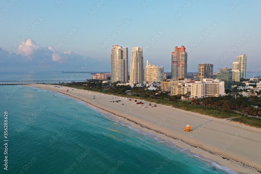 Aerial view of South Pointe Park and South Beach in Miami Beach, Florida at sunrise with Port Miami and City of Miami skyline in background. Aerial view of South Pointe Park and South Beach in Miami Beach, Florida at sunrise with Port Miami and City of Miami skyline in background.
