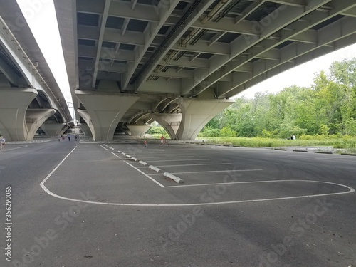 asphalt road underneath a large bridge