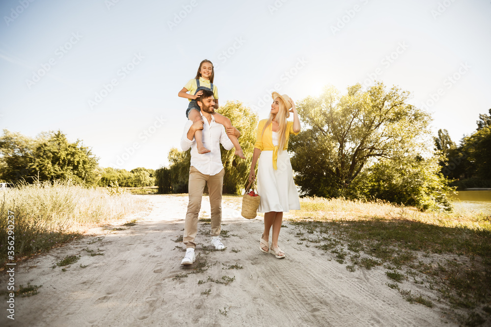 Happy Family Walking In Countryside Spending Day Outside Near River