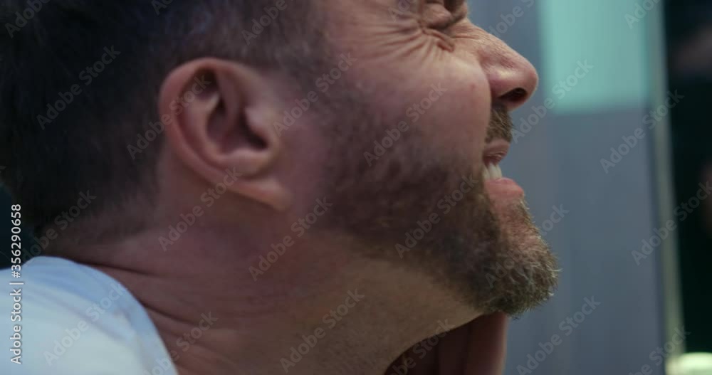 Bearded blond man standing in bathroom, looking at himself in the mirror. Bearded blond man standing in bathroom, looking at himself in the mirror.