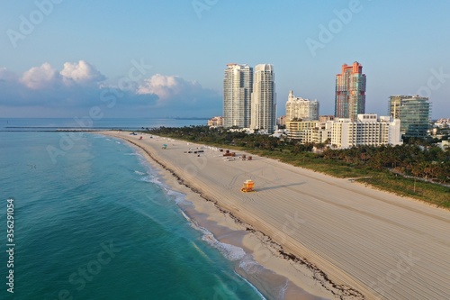 Aerial view of South Pointe Park and South Beach in Miami Beach, Florida at sunrise with Port Miami and City of Miami skyline in background.