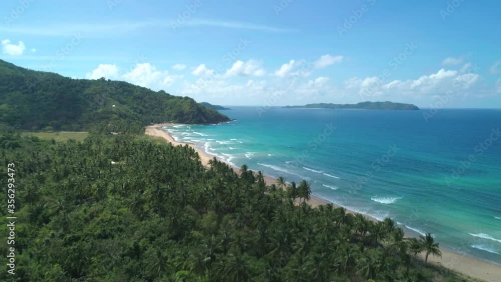 Aerial view of tropical sandy beach in bay with blue water. Seascape with sea, sand, palm trees. Top view of paradise island. Summer and travel vacation concept. Aerial view of tropical sandy beach in bay with blue water. Seascape with sea, sand, palm trees. Top view of paradise island. Summer and travel vacation concept.