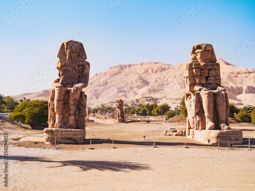 Ruined androsphinx statues near Hatshepsut temple, long view. High mountain on horizon. Photographed in Dayr al Bahri, Luxor. Selective soft focus. Blurred background