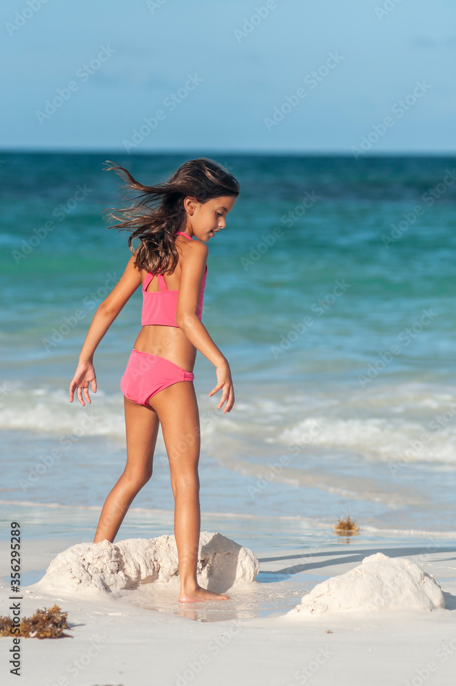 Niña en bikini rosa en playa azul del mar caribe durante vacaciones de  verano Stock Photo | Adobe Stock