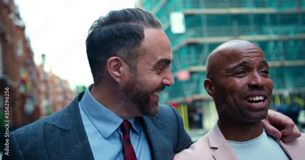 Mixed race homosexual couple walking down a street in London, England. Mixed race homosexual couple walking down a street in London, England.