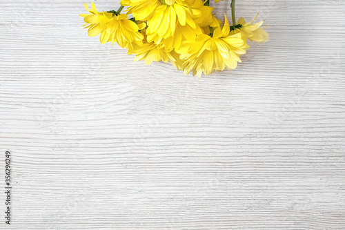 happy morning photo of a bouquet of yellow daisies on top of the frame on a white wooden background