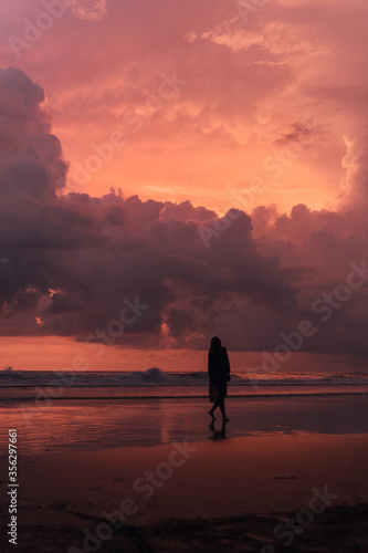 social distancing on the beach , pink and orange amazing cloudy sky , beautiful sunset , Bali Indonesia , solo outdoor walking  © Dmitry