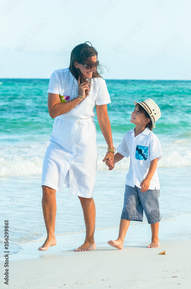 Foto de Mujer y niño con ropa de verano pasea juntos en playa del mar  Caribe durante las vacaciones. do Stock