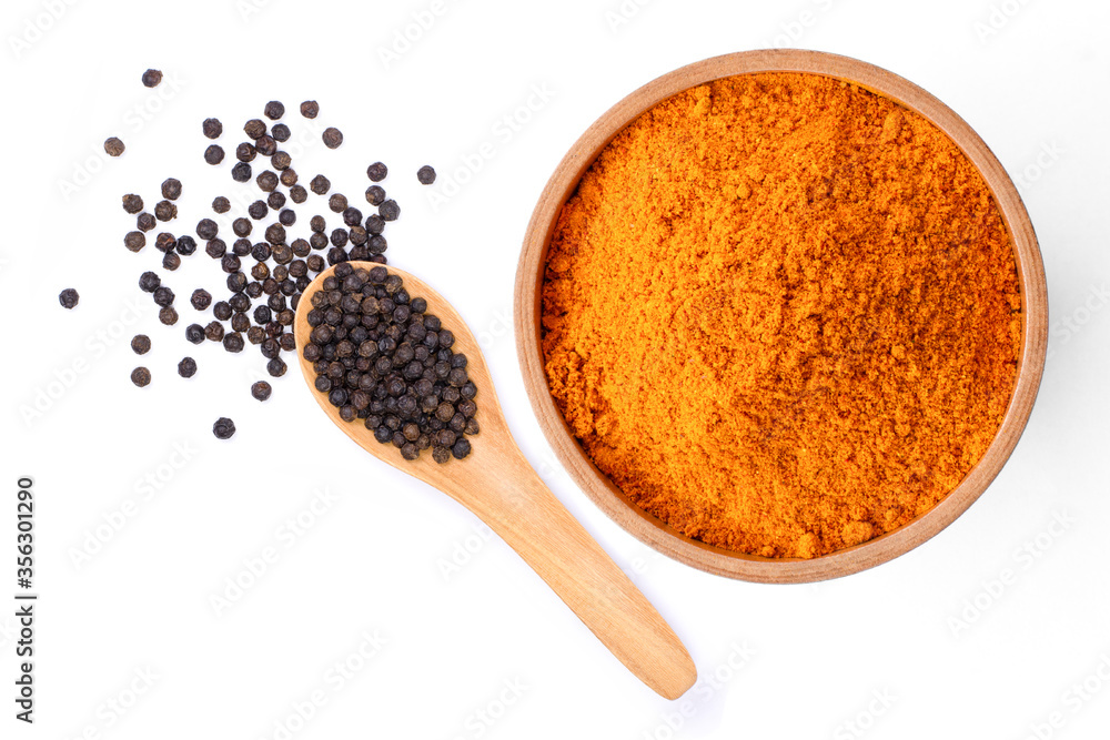 Curcumin powder ( tumeric ground, turmeric, Curcuma ) in wooden bowl and black pepper isolated on white background. Health benefits and antioxidant food concept. Top view. Curcumin powder ( tumeric ground, turmeric, Curcuma ) in wooden bowl and black pepper isolated on white background. Health benefits and antioxidant food concept. Top view.