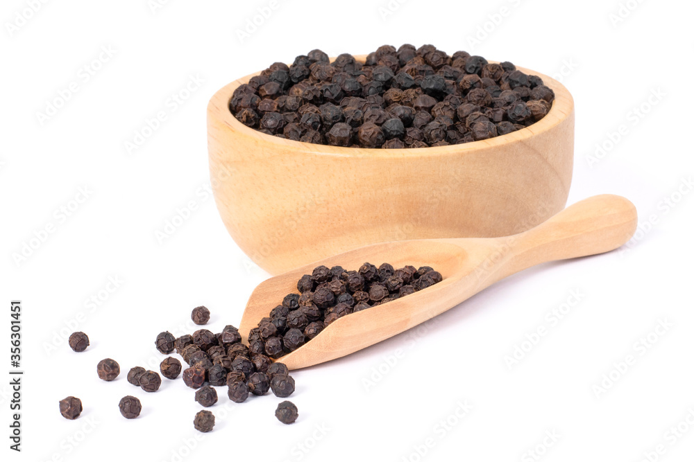 Closeup black pepper seeds or peppercorns ( dried seeds of piper nigrum, piperine ) in wooden bowl and scoop isolated on white background. Closeup black pepper seeds or peppercorns ( dried seeds of piper nigrum, piperine ) in wooden bowl and scoop isolated on white background.