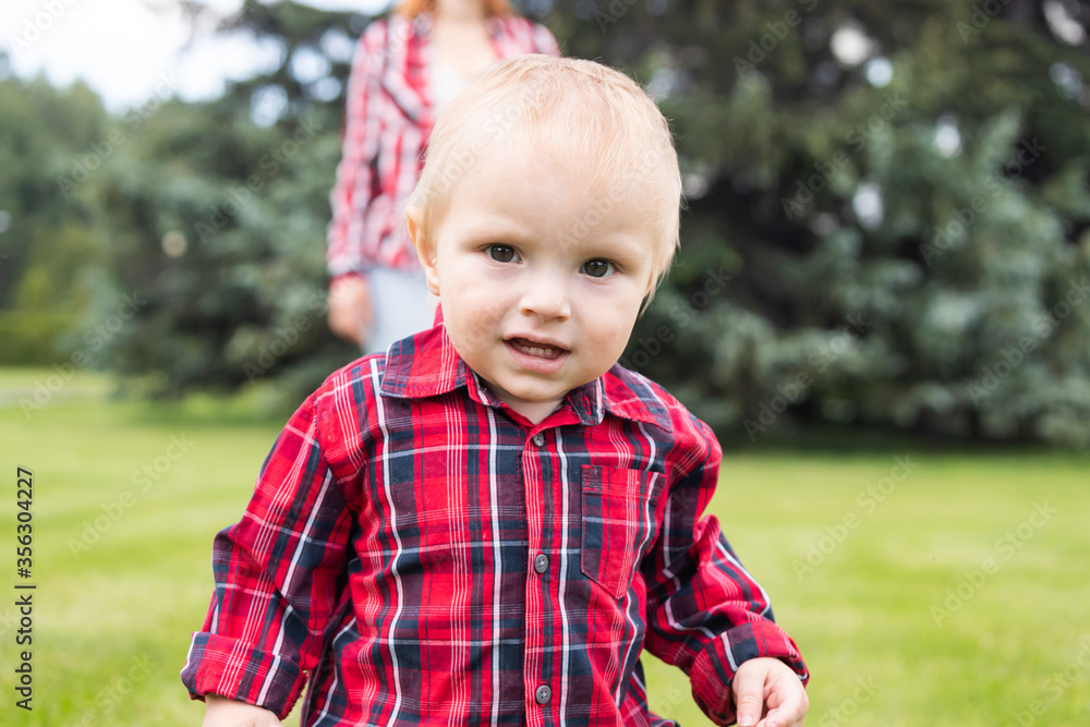 Portrait, Little boy walking on the field. Funny child in the park in summer. The concept of summer time and happy childhood. Portrait, Little boy walking on the field. Funny child in the park in summer. The concept of summer time and happy childhood.