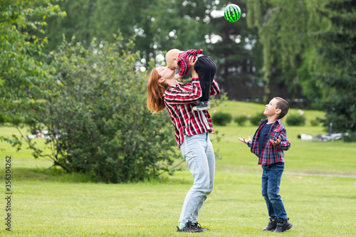 Cute cheerful two boys brother child with mother play outdoors in park. Happiness and harmony of family life. Great family vacation.
