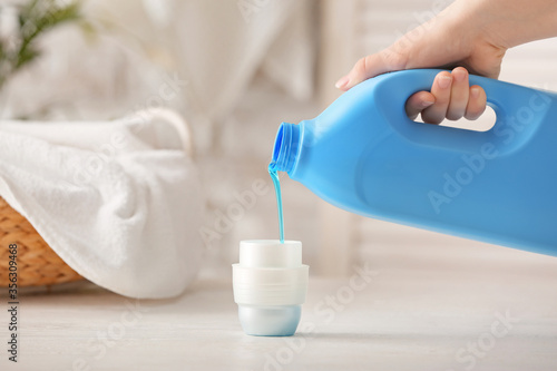 Woman with laundry detergent at home photo